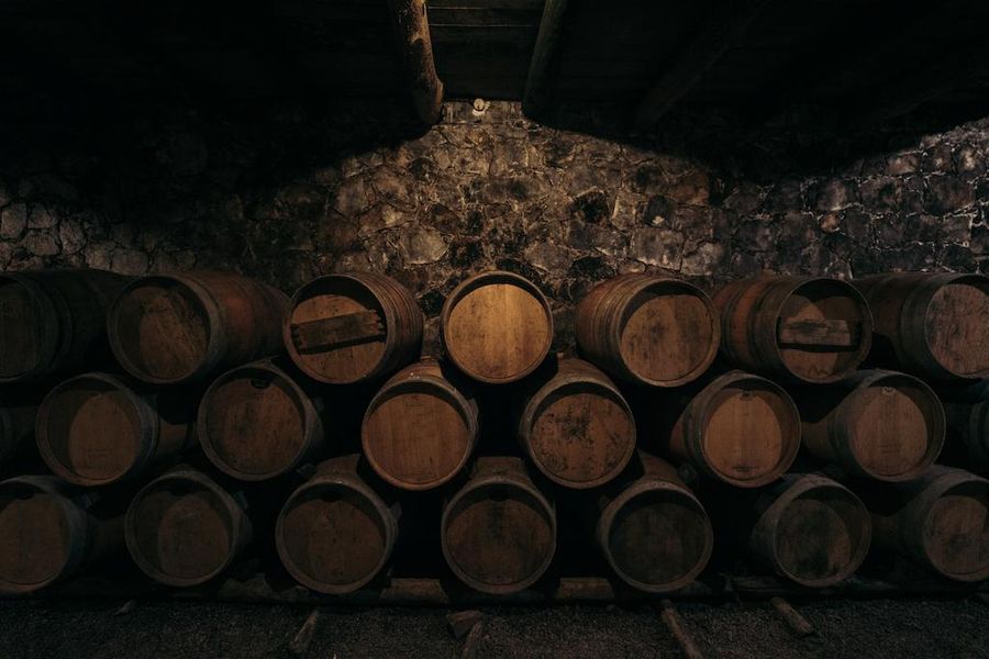 wine wood barrels on top of each other at Dourakis winery stone cellar
